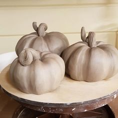 three white pumpkins sitting on top of a table