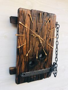 a clock made out of wood with chains hanging from it's sides and hands