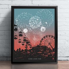 a framed poster with fireworks in the sky above a cityscape and ferris wheel