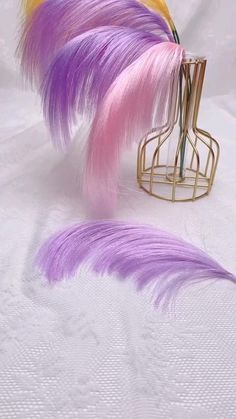 purple and yellow feathers are in a wire holder