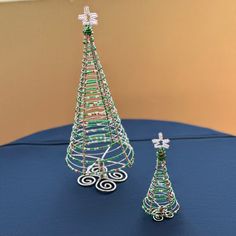 two wire christmas trees sitting on top of a table