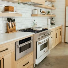 a kitchen with an oven, stove and counter tops in wood cabinets on the wall