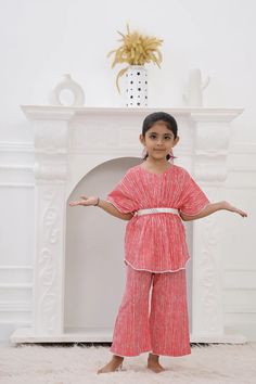 Our Girls Kaftan Set is a must-have for your Girls. Made with 100% pure cotton cambric, this Kaftan Set is quite soft and tactile to touch making it a perfect match for your small one. Traditional print in pretty colours makes this kurta look distinctively good while wearing it. Composition: 100% cotton cambric The Kaftan Set is a gorgeous set of two pieces, includes a white cotton lace on Kaftan sleeves, Kaftan flare & pant bottom. The elasticated kaftan with a belt & loop for belt and elasticized pants to match, it has a button at the back that can be made secure or open, as you wish! Wash care : Hand wash separately in cold water. Use mild detergent. Dry in shade. Cotton Short Sleeve Sets For Eid, Short Sleeve Cotton Sets For Eid, Festive Short Sleeve Cotton Kurta, Festive Cotton Kurta With Short Sleeves, Pink Cotton Sets For Festive Occasions, Red Cotton Matching Set, Festive Cotton Short Sleeve Sets, Pink Cotton Dress For Navratri, Red Cotton Dress For Diwali