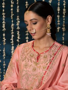 "Jashn-E-Ulfat" - a collection of ensembles that evoke a sense of majestic opulence and modern royalty. Suffused with deep rich hues set on plush cotton silk enhanced with remarkable craftsmanship like Marodi, Mirror and Zardozi embroidery, each ensemble has a romantic and feminine charm of its own collection. This set of 3 consists of a Kurta, Salwar and Dupatta. Kurta: This dainty peach chanderi silk kurta is enhanced with handcrafted zardozi, sitara and zardozi jaal work on the neck, buttas o Elegant Straight Kurta Choli With Resham Embroidery, Chinon Straight Kurta Set For Reception, Kundan Straight Kurta Set For Transitional Season, Elegant Straight Kurta Set With Cutdana, Elegant Sets With Gota Work In Chinon, Elegant Straight Kurta Choli For Diwali, Elegant Navratri Sets With Gota Work, Elegant Sets In Chinon With Gota Work, Designer Sets With Intricate Embroidery And Traditional Drape