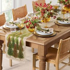 a dining room table set for christmas with place mats and placemats on it