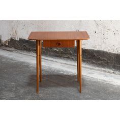 a small wooden table sitting on top of a cement floor