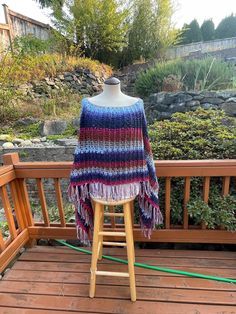 This beautiful warm crochet  poncho  with fringe is a good addition to many outfits from dress-up to casual wear.  The variegated colors in the yarn really compliment each other and the stitch used gives the texture that makes the colors stand out. The fringe adds a bit of length. If you prefer the poncho without fringe please let me know I can make the adjustments.  You can wear this poncho as a triangle poncho or square poncho.   **This poncho is made and ready to ship.**.  This is a  one size fits most. Measurements are width about 36 inches and the length is about 37 inches.   If you have a color or a different size that you prefer, I would be happy to see if the yarn is available and go from there as a custom order.  This poncho can be washed on gentle cycle with cold water no spin an One Size Knit Poncho With Fringe, Blue Fringe Poncho One Size, One Size Poncho With Tassels In Cape Shape, Multicolor Fringe Poncho For The Beach, Blue One-size Poncho With Fringe, One Size Blue Poncho With Fringe, Multicolor Fringe Poncho For Beach, Beach Poncho With Fringe In Multicolor, Beach Poncho With Multicolor Fringe