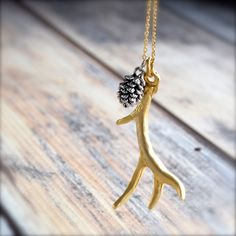 "A pretty, matte gold antler/branch pendant is paired with a sweet little silver pinecone on a 28 - 30\" gold plated chain.   The antler or branch pendant measures approx. 1.5\" (4cm) from top of the loop to longest point, and the pinecone is about .5\" long (6mm) and 3 dimensional.   The chain can be worn at it's shortest, 28\" length, and extends to 30\".  This piece is finished with a lobster clasp.   This pretty gold chain is plated over brass.  Brass is a friendly metal, and all components are nickel and lead free, and tarnish resistant.  Your antler/branch necklace will be packaged pretty with a gift box, signature tissue, and wrapped in an organza bag - ready for giving or to enjoy yourself. This is the original Antler & Pine Cone necklace on Etsy. I coat the pendants with a durable Elk Ivory Jewelry, Necklace Long Gold, Gemstone Wrap Bracelet, Pinecone Necklace, Long Gold Necklace, Antler Pendant, Antler Jewelry, Antler Necklace, Branch Necklace