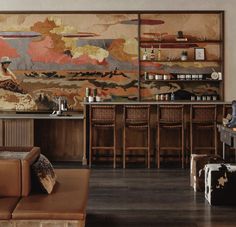 a living room filled with furniture and a painting on the wall above it's bar