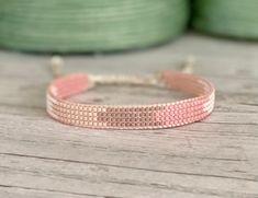 a pink beaded bracelet sitting on top of a wooden table