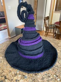 a crocheted hat sitting on top of a counter next to a chair and table