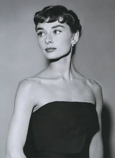 black and white photograph of a woman in a strapless dress with her hands on her hips