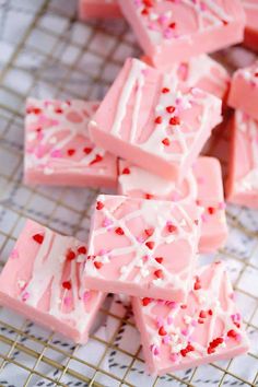 pink and white chocolate with sprinkles on a cooling rack