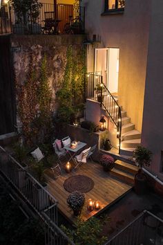 an outdoor patio with candles on the table and stairs leading up to the second floor