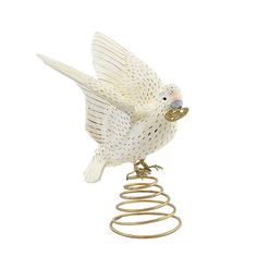 a white bird sitting on top of a metal spiral object with its wings spread out