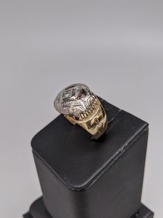 This ring is made of 10k white and yellow gold. The mounting is yellow with different inscriptions made into it. The Masonic symbol is in white gold and has a small round diamond set in the center. The face of the ring is 14mm wide and tapers down. Size 9, but can be resized up or down two sizes free of charge. Symbolic White Gold Diamond Ring, Formal Symbolic White Gold Rings, Symbolic White Gold Rings For Formal Occasions, Symbolic Etched Yellow Gold Rings, Symbolic Skull Ring For Anniversary, Diamond Rings Symbolic For Formal Occasions, Formal Symbolic Diamond Ring, Symbolic Diamond Ring For Formal Occasions, Symbolic White Gold Skull Ring For Anniversary