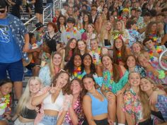 a group of young women standing next to each other in front of a crowd of people