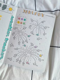 an open planner book with fireworks and numbers on the pages, sitting on a bed