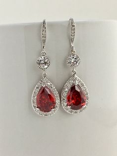 pair of red and white cubicge drop earrings with diamonds on the bottom, set in 18k white gold