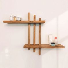 two wooden shelves with various items on them and one shelf has a mirror above it