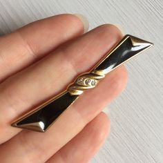 Black enamel bow brooch. Vintage costume jewelry. Good as a scarf, shawl, lapel, or collar pin for women.  ✔ Gold-tone metal. Black enamel. Clear rhinestones  ✔ Size: 6*1 cm, 2 1/4 x 1/2 inch ✔ Condition: very good vintage ✔ Mark: not signed ✔ C clasp ✔ Gift wrapping See more vintage brooches https://www.etsy.com/shop/OldJewelBox?ref=seller-platform-mcnav&section_id=24707449 Chic Black Brooch As A Gift, Chic Black Brooch For Gift, Elegant Formal Enamel Pin Brooch, Chic Black Brooches For Gifts, Elegant Enamel Brooch Pin, Black Brooch With Decorative Bow Gift, Antique Black Brooch For Gift, Vintage Black Brooch Lapel Pin, Cute Enamel Pins