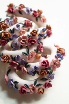 there are many different flowers on the hair clip set in this photo, one is white and has multicolored roses