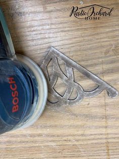 a pair of scissors sitting on top of a wooden table next to a bottle opener