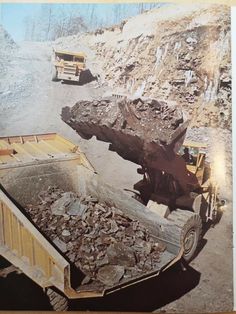 an old photo of dump trucks and large rocks on the side of a mountain road