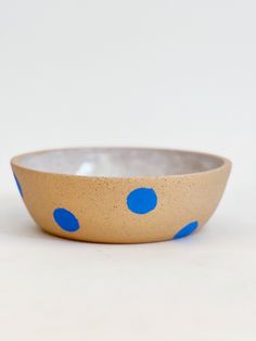 a blue and white polka dot bowl sitting on top of a table