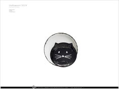 a black cat in a white bowl with its eyes closed and it's head sticking out