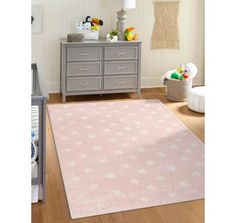 a baby's room with a pink rug and grey dresser