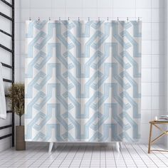 a white and blue shower curtain in a bathroom with tile flooring on the walls