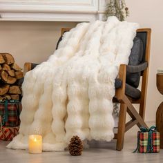 a white blanket sitting on top of a wooden chair next to a pile of presents