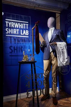 a mannequin wearing a suit and tie in front of a t - shirt lab