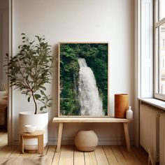 a white room with a waterfall in the middle and a potted plant on the floor