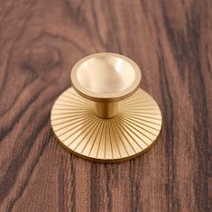 a brass plate on a wooden surface with an object in the middle that looks like a sunburst