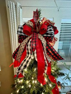 a christmas tree decorated with red, white and black bows