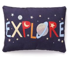 an embroidered pillow with the word explore written in colorful letters and stars, on a dark blue background