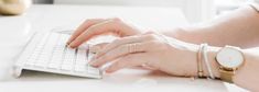 a woman is typing on her computer keyboard