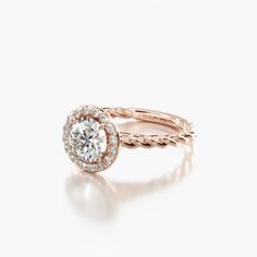 a rose gold engagement ring with an oval diamond in the center and roped band