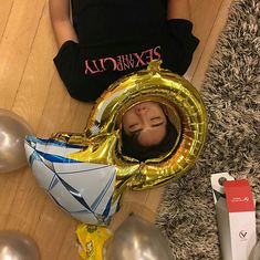 a person laying on the floor with some balloons