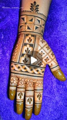 the hand is decorated with henna designs on it and has an intricate design that looks like