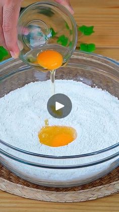 someone mixing ingredients in a bowl on a wooden table