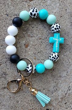 a bracelet with cross charms and tassels on the front is laying in the sand