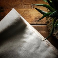 a pineapple sitting on top of a wooden table next to a piece of cloth