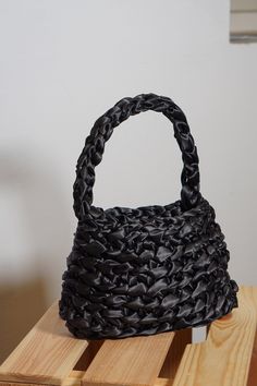 "This beautiful handbag is a perfect blend of craftsmanship and elegance. Carefully crocheted by me, this unique accessory is designed to elevate your style and make a statement wherever you go. This handbag holds a phone of any size, is comfortable to hold in your hand and it compliments every outfit. It s perfect as a Mother's Day gift, Valentines gift or a \"just because\"-gift.  Key features: 🤍 Material: Immerse yourself in luxury with the finest satin ribbon meticulously crocheted to perfection. The silky-smooth texture not only adds a touch of opulence but also ensures durability, making this bag a timeless addition to your collection. 🤍 Dimensions: With a compact size of 22 x 15 x 3 cm, this bag strikes the ideal balance between functionality and style. It's spacious enough to acc Evening Shoulder Bag With Braided Handles, Black Woven Handheld Shoulder Bag, Evening Bags With Braided Double Handles, Chic Crochet Bag With Double Handle And Removable Pouch, Chic Crochet Bag With Removable Pouch And Double Handle, Elegant Crochet Bag With Braided Double Handles, Evening Shoulder Bag With Braided Double Handles, Black Woven Top Handle Bucket Bag, Black Rectangular Bucket Bag For Party