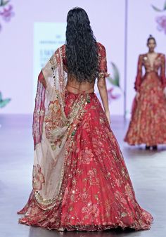 Embrace the splendour of your big day with our Red Embroidered Bridal Lehenga Set, befitting the modern bride who cherishes tradition with a touch of contemporary flair. This exquisite bridal lehenga radiates elegance in a vibrant shade of red, adorned with a lush floral print and royal embroidery that promises to captivate. The classic half-sleeved blouse is reimagined with a modern cut, while the shimmering organza dupatta, embellished with statement floral motifs, cascades gracefully, completing your bridal silhouette. Perfect for the bride who desires to blend timeless elegance with modern sophistication, this set will ensure all eyes are on you as you walk down the aisle. Composition : Lehenga, Blouse, Dupatta - Organza, Shantoon Care: Dry Clean Only and Vacuum Storage This product ca Red Embroidered Fabric With Sheer Dupatta For Reception, Bridal Silhouette, Royal Embroidery, Mahima Mahajan, Embroidered Bridal Lehenga, Lehenga Style Saree, Indian Bridesmaid Dresses, Lehenga Style, Vacuum Storage