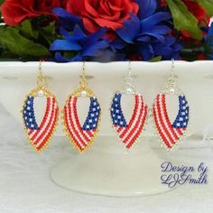 three pairs of patriotic beaded earrings on a white plate with red, white and blue flowers in the background