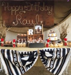 an outdoor birthday party with food and desserts on the table, along with a sign that says happy birthday paul