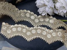 two pieces of lace next to flowers on a table